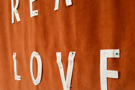 Close up of handmade banner with pinned letters that read LOVE