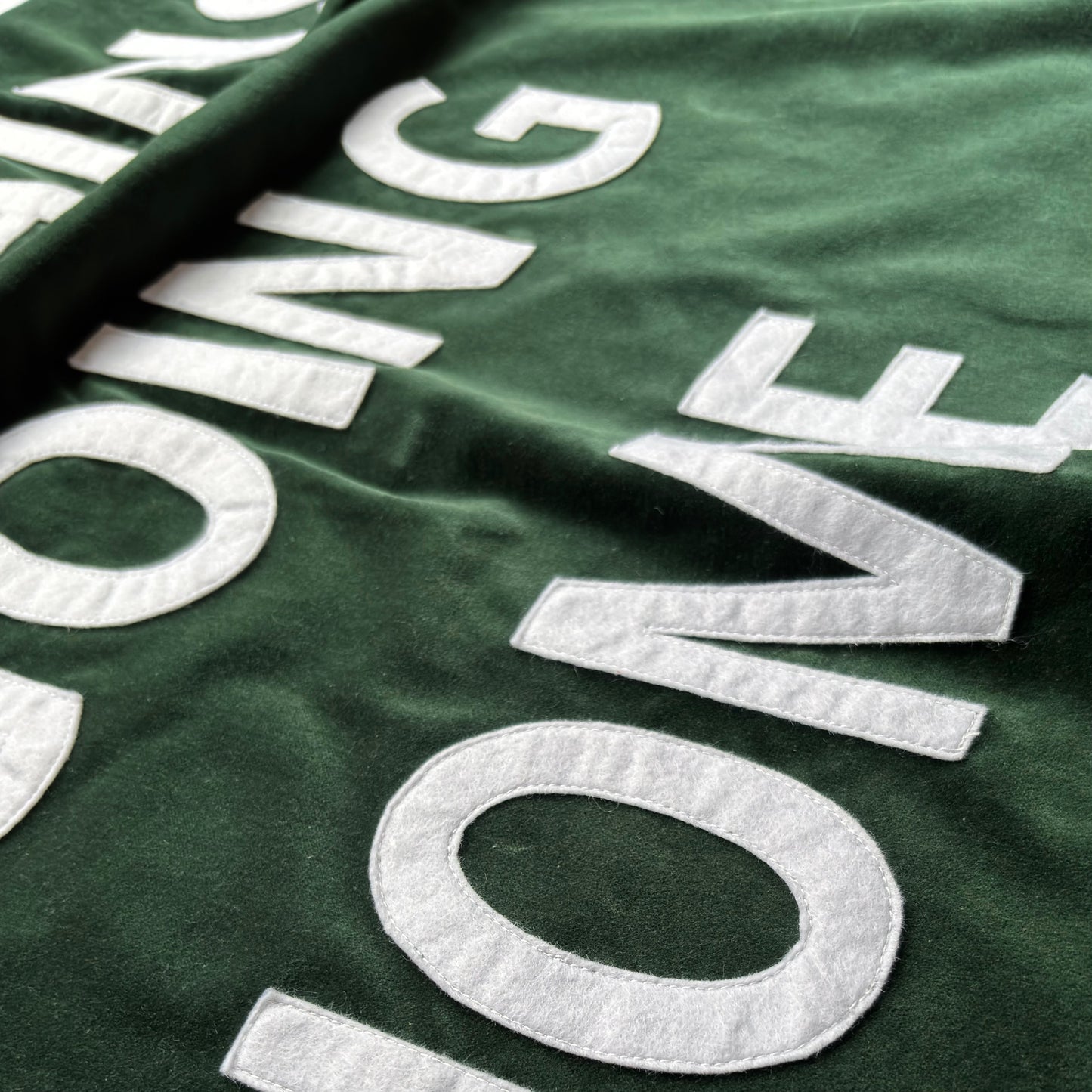 Close up of bottle green velvet handmade banner with white felt letters.