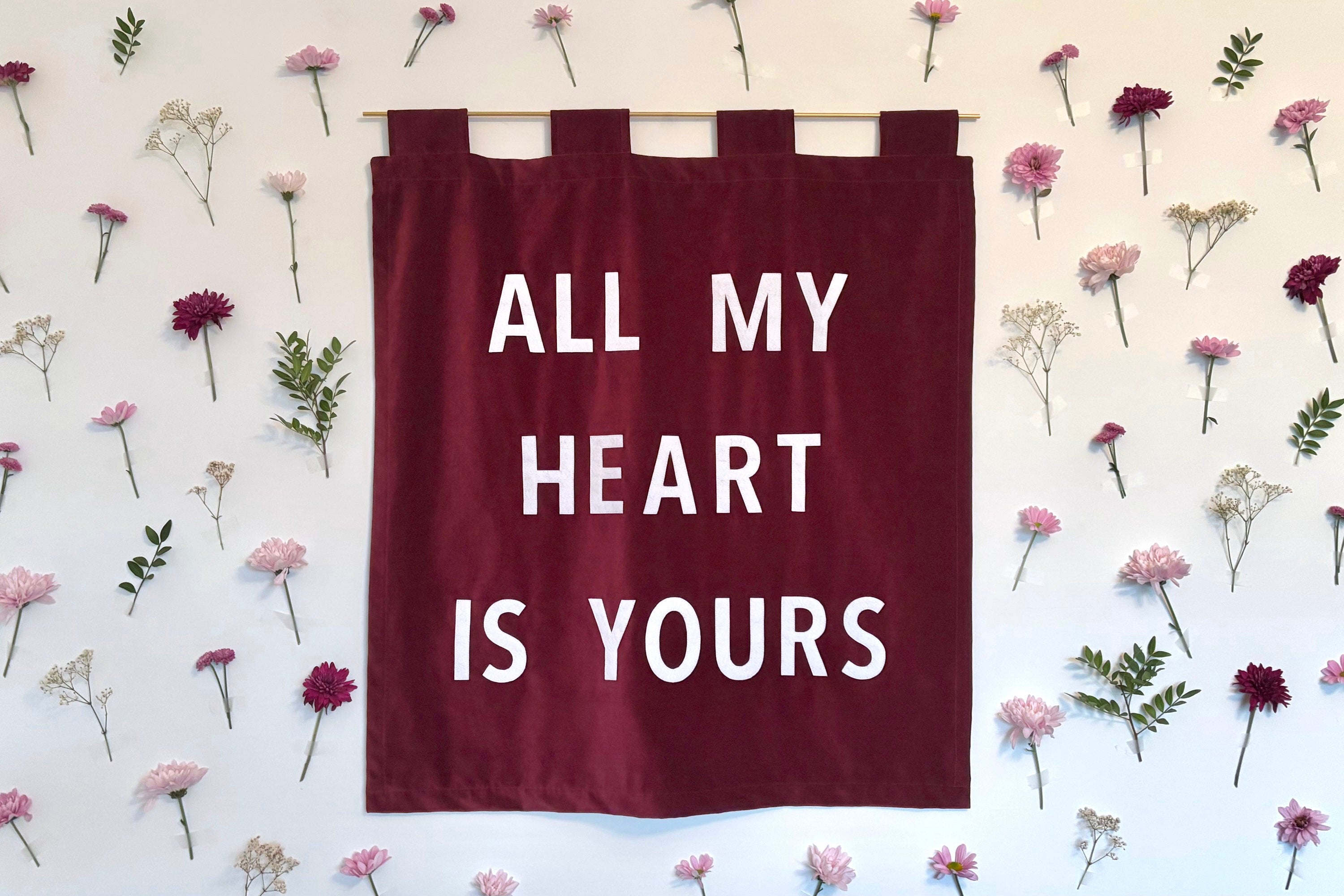 A red velvet wedding banner with "All my heart is yours" on a white floral background.