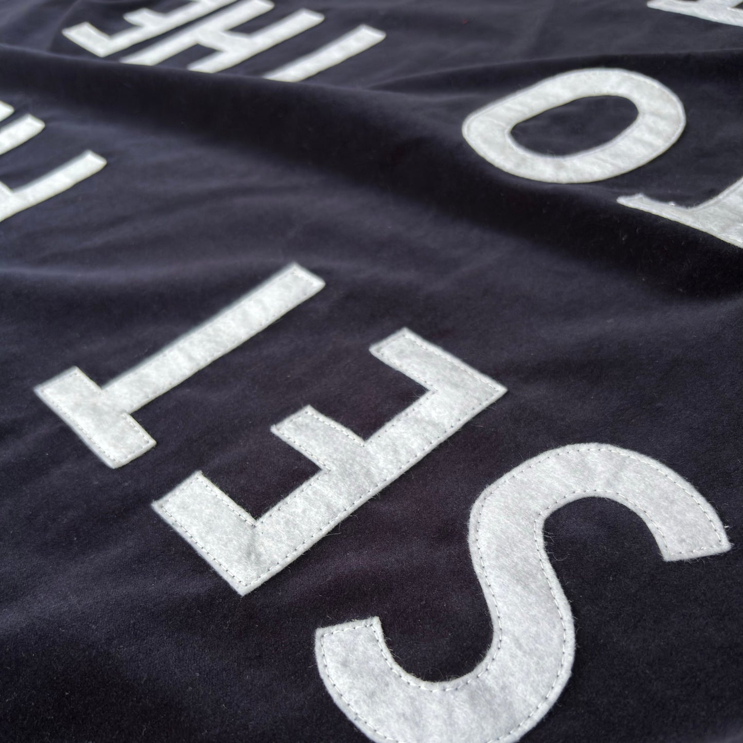 Close up of midnight blue velvet handmade banner with white felt letters.