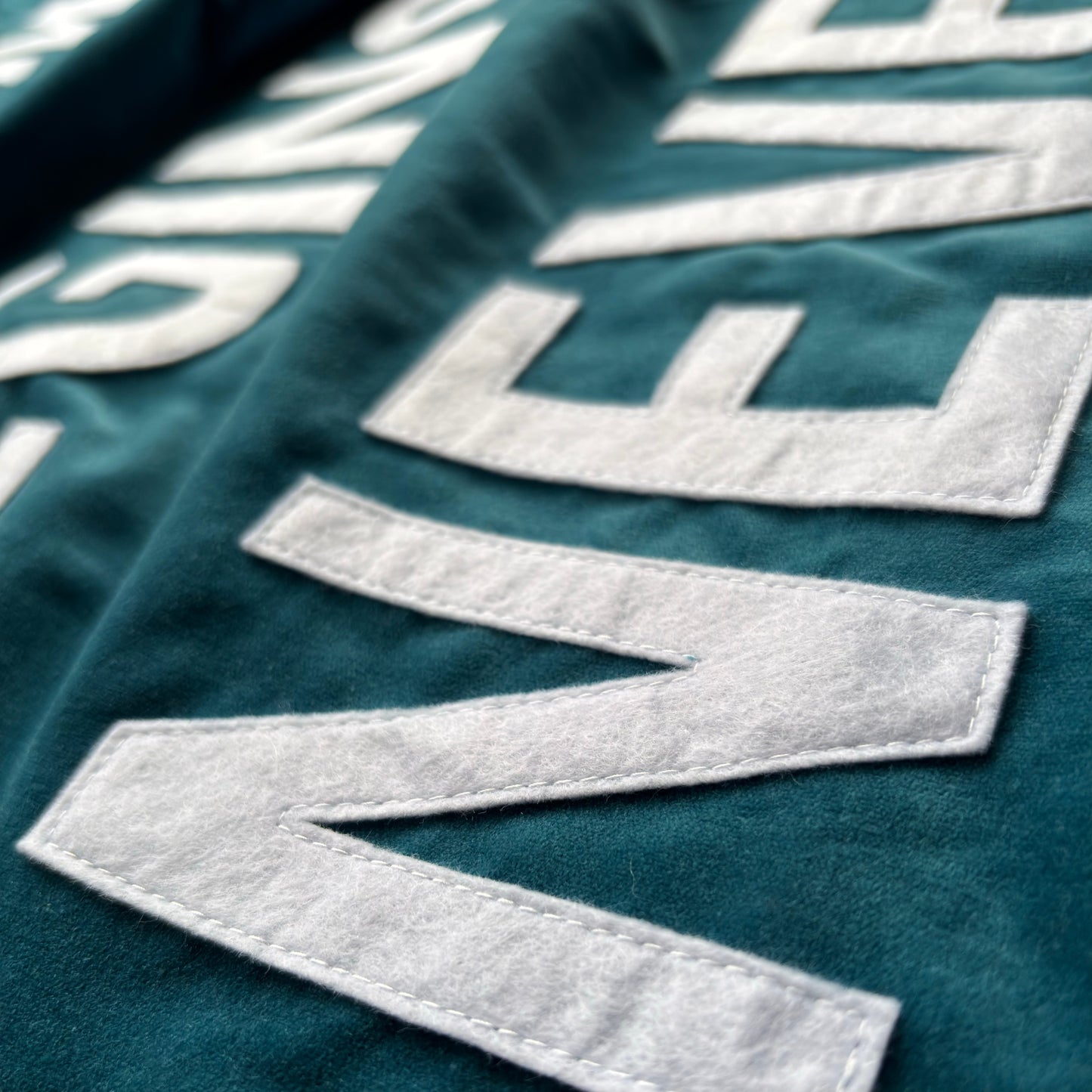 Close up of teal blue velvet handmade banner with white felt letters.
