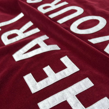 Close up of wine red velvet handmade banner with white felt letters.