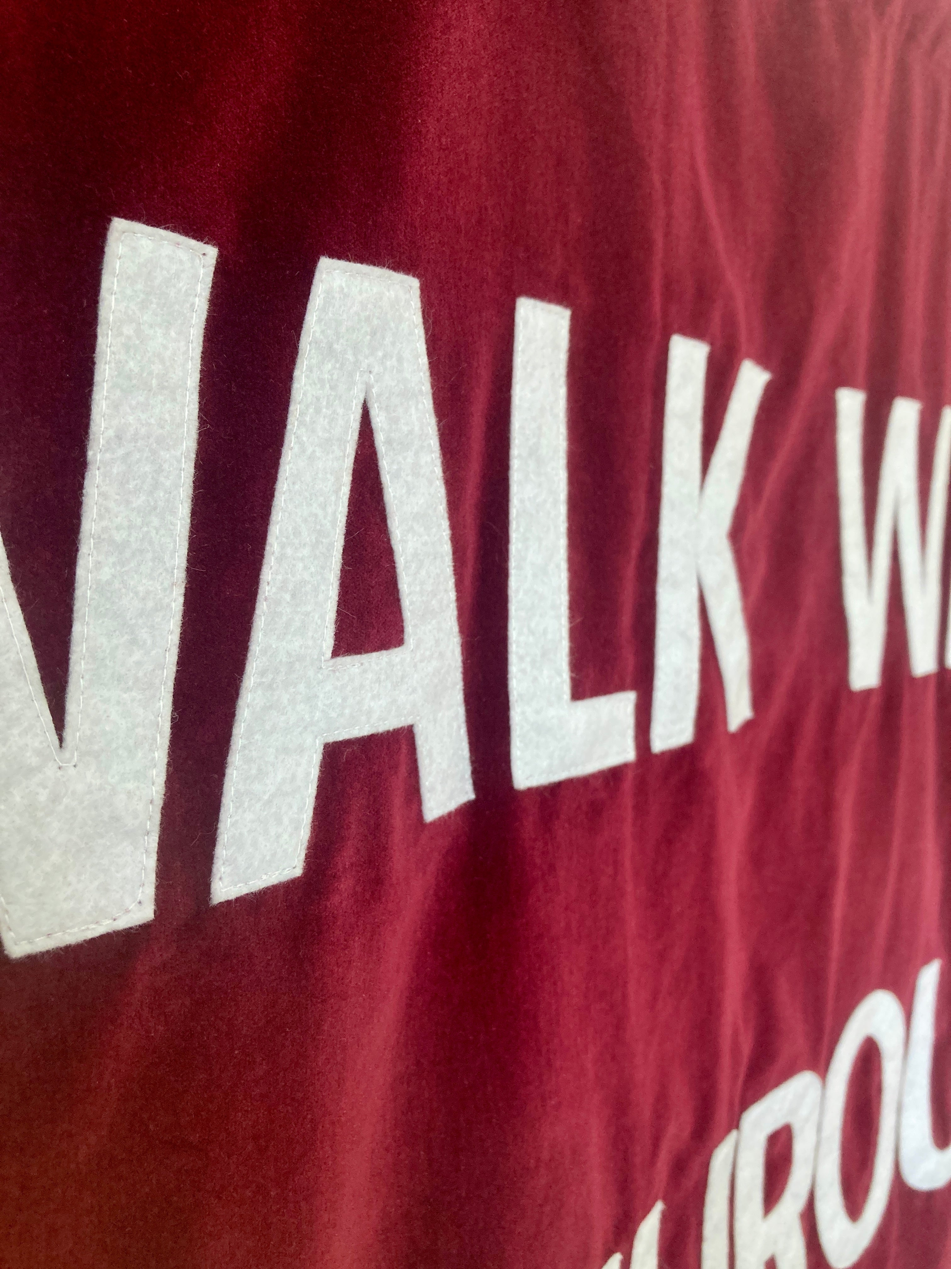 Close up of a red velvet banner with white text.